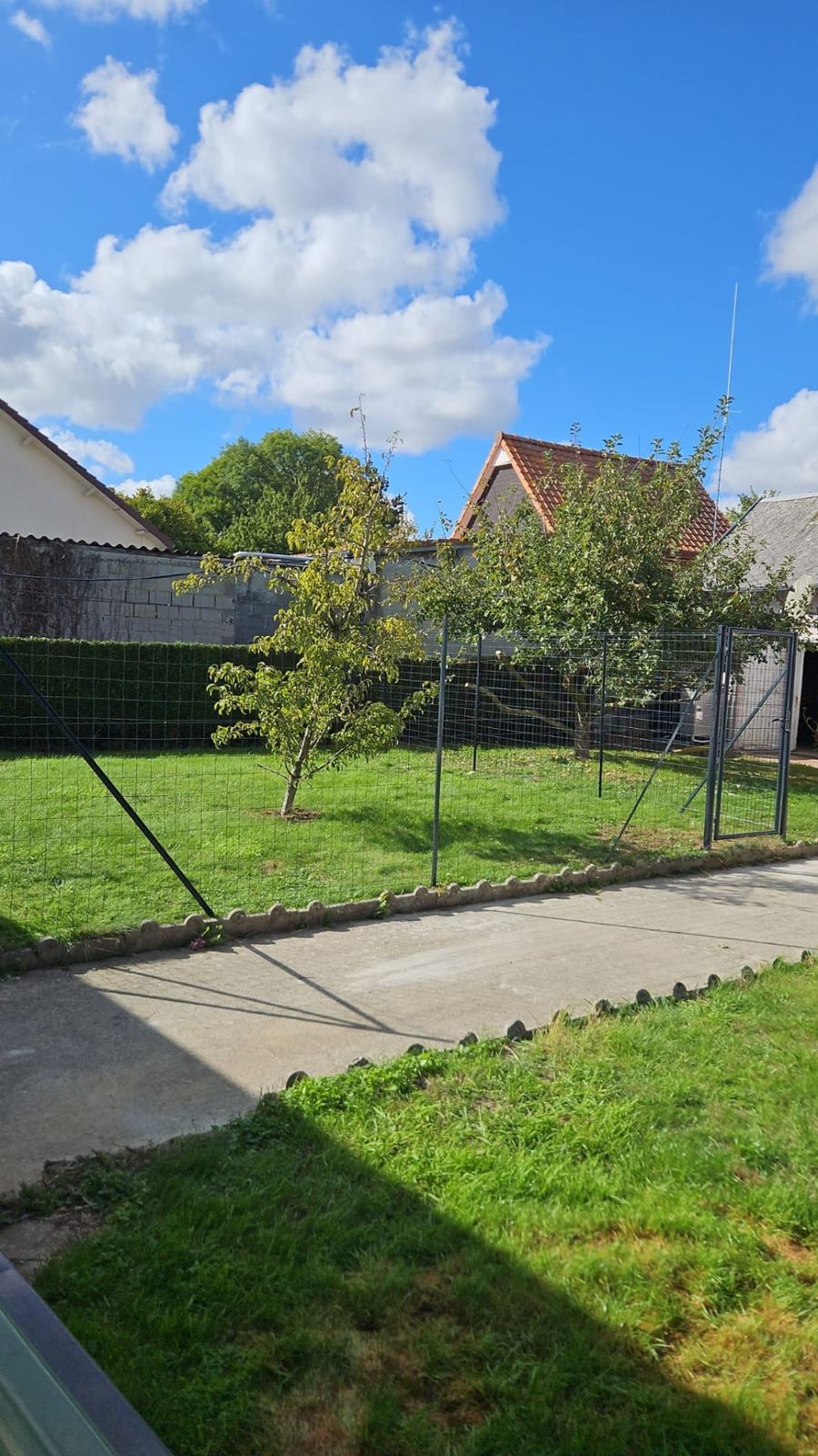 Le même jardin sécurisé par un grillage avec portail après l'implantation du parc à chien